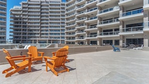 Adirondack chairs on tech expansive tiled patio.