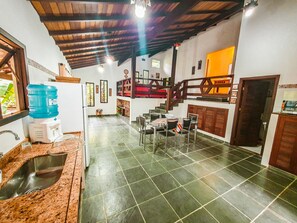 Vista geral da cozinha e escada para a sala de estar e suítes.