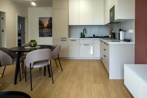 The bright kitchen open to the living room allows for shared cooking and dining – a functional and well-lit space.
