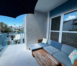 View of the balcony facing the pool, plus comfortable seating an - View of the balcony facing the pool, plus comfortable seating and shade from the umbrella.