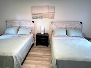 Bedroom #1 two queen beds, Roku TV, USB outlet, closet with hangers and dresser
