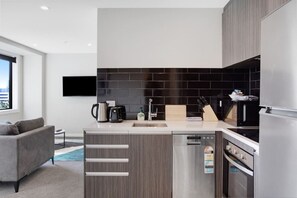 The kitchen has a cook top, oven, dishwasher, microwave and fridge/freezer.
