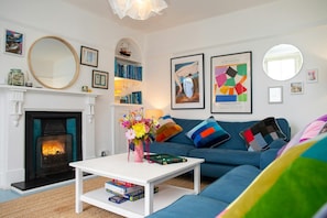 Sitting room with two large sofas, coffee table and open fire