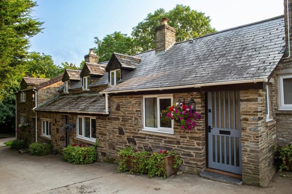 Freesia Cottage with hanging basket and potted plants outside