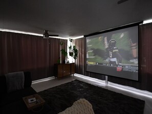 Sunroom with blackout curtains and projector