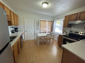 Full kitchen with stove/oven, dishwasher, coffee maker, full fridge, & cookware