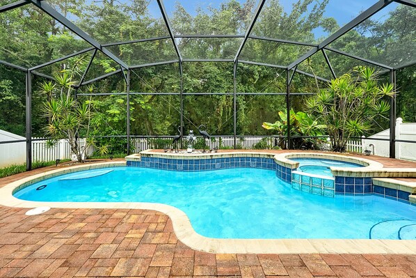 Dive into your private screened-in pool and spa