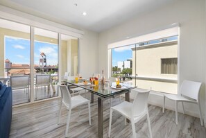 Featuring a sleek glass table with comfortable seating for four, the space is perfect for intimate meals or casual gatherings.
