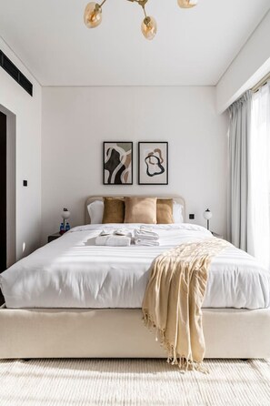 Cozy bed with plush pillows, a soft duvet, and stylish wall decor above the headboard