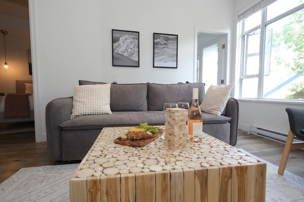 Living Room features a large sofabed, 2 lounge chairs, square coffee table for games & snacking. The artwork features scenery of Whistler & Blackcomb taken by a pro photographer.Note: Wine & food is staged for illustration (not included)