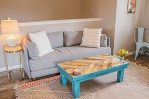 Bright and inviting living room. The couch pulls out into a queen sofa bed. 