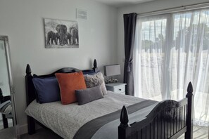 Bright and spacious bedroom with en-suite bathroom, large mirrors, and an external door leading to beautiful countryside views!