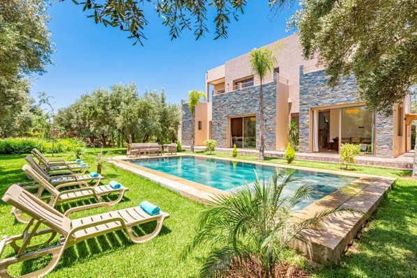 Villa Kamelia : piscine et jardin luxuriant pour une détente parfaite.