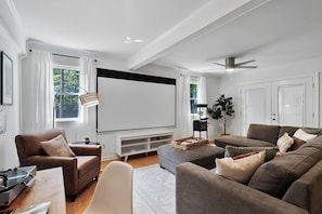 Movie theatre room with large screen projector and cozy seating