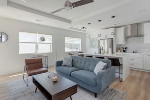 Open concept living room and kitchen with vaulted ceilings.