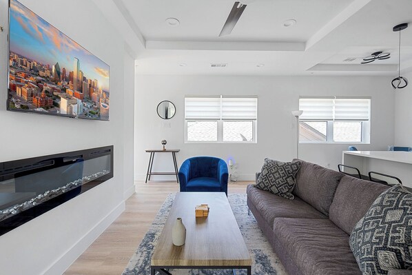 Open concept living room and kitchen with vaulted ceilings.
