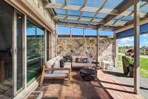 The outdoor patio area is comfortably furnished with sofas to kick back and enjoy the serene beachfront setting.
