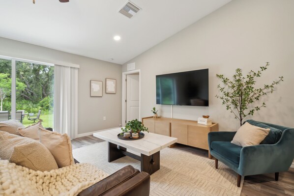 Welcome to your cozy living space at The Balboa with couch, armchair, throw blankets, pillows, and Smart TV