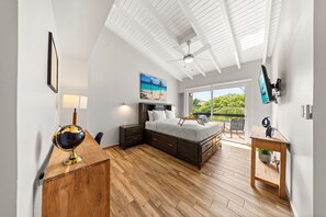 Spacious bedroom with a king-size bed, wood floors, and a balcony with views.
