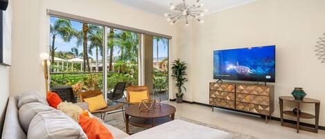 The glass doors flood the room with natural light, complementing the cozy interior design. A wall-mounted TV adds entertainment for a perfect space to enjoy during your stay.