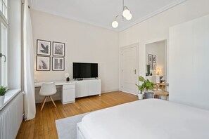 Spacious bedroom with a comfortable double bed, stylish decor, and a cozy work area, perfect for relaxation or remote work.