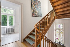 Elegant wooden staircase featuring stained glass accents and artistic decor, adding a touch of character to the space.