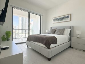The bedroom is a restful haven featuring a soft bed, a flat-screen TV, and a private balcony. Start your morning with fresh air and a beautiful view, or wind down in the evening with a show and a peaceful moment outside.