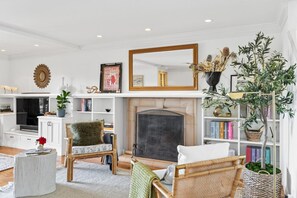 Unwind in style in our beautifully designed living room, featuring Serena and Lily decor, thoughtfully styled bookshelves, a smart TV, and a premium sound system for the perfect blend of comfort and entertainment.