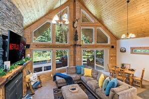 Cozy up on the spacious sofa under the open ceiling—your perfect cabin retreat!