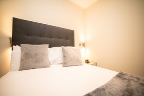 "Peaceful bedroom with a plush bed and soft lighting."
