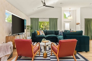 Large living room with large sectional and 75 inch smart Roku TV and Sonos Bar