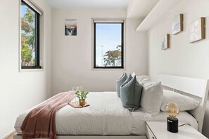 A bedroom with a double sized bed & plush pillows.