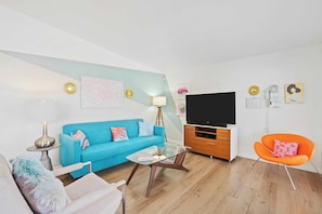 Bright living area with comfy seating and Smart TV