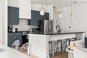 This fully stocked kitchen boasts a spacious kitchen island with seating for six, perfect for casual dining and socializing.