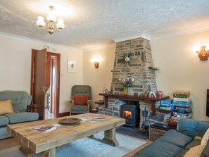 Stone fireplace with wood burner, coffee table and sofas