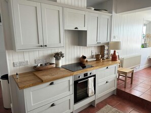 Kitchen with electric oven and wall and base cupboards