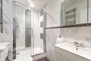 Modern bathroom with walk-in shower, large basin and vanity mirror