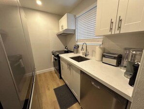 Full kitchen with fridge, stove and dishwasher.