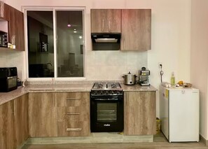 Cocina con refrigerador, horno, licuadora, cafetera y olla de lento cocimiento 