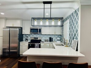Ample fully stocked kitchen with refrigerator, range, microwave and dishwasher.
