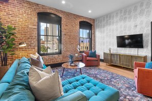Relax in the living area with a smart TV, stylish seating, and a sleeper sofa for extra guests. Perfect for families or group stays in New Orleans, this inviting space is ideal for movie nights or recharging after a day in the city.