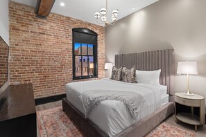 The primary bathroom offers sleek finishes, a soaking tub with Smart TV, walk-in shower, and plush towels. Spacious and private, it adds a luxurious touch to your suite—perfect for unwinding after a day in Downtown New Orleans.
