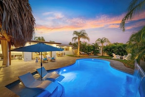 As the sun sets, the pool area glows, creating the perfect atmosphere for a night of backyard bliss.