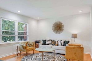 Relax in our stylish living room, featuring cozy sofa seating and a large flat-screen TV. Perfect for unwinding after a day of exploring or enjoying cozy nights in.