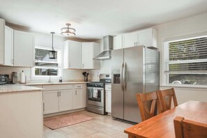 Cook and gather in our modern kitchen, featuring all the essentials and sleek appliances for both meal preparation and casual dining.