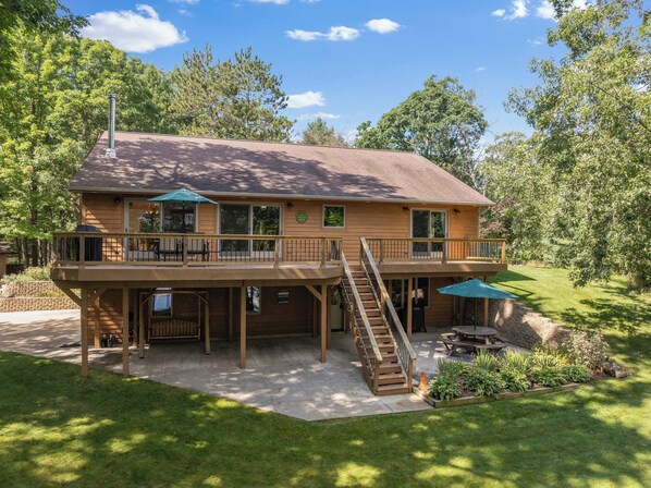 Lake-facing deck and patio with various outdoor seating, grill, and smoker.