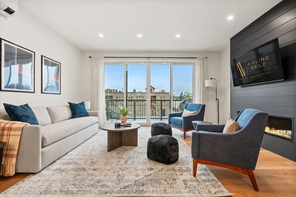 Main living room (located on the 2nd floor) with a fireplace feature, Smart TV, cozy seating & access to the balcony's BBQ (propane's on us!)