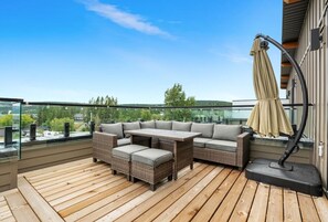 Private patio space (located on the 3rd floor) with an oversized outdoor sectional, umbrella & nest chair.
