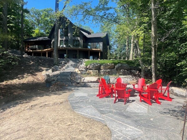 Classic Muskoka cottage with beach and lake front fire pit.