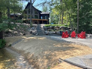 Classic Muskoka cottage with beach and lake front fire pit.
